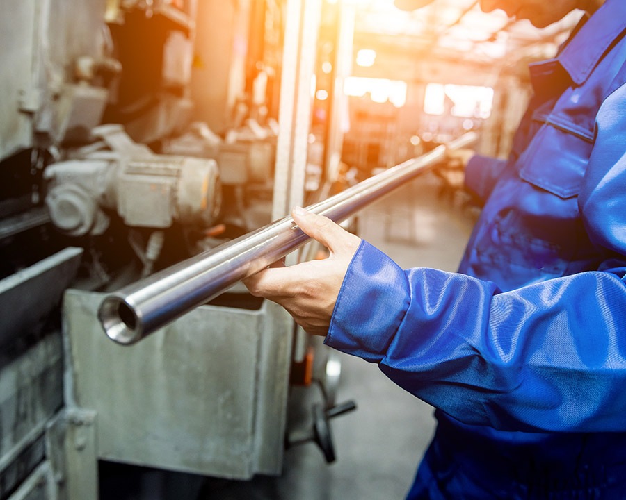 Worker checking metal pipes at a metallurgical plant.